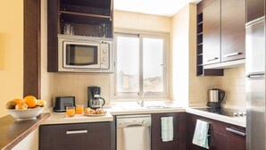 A modern kitchen with dark wooden cabinets, a built-in microwave, a dishwasher, and a stainless steel refrigerator. - Benalmadena Principe 3p4p Balcon (Benalmádena)