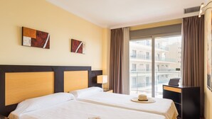 A hotel room with two beds, a desk, a laptop, and a view of the city. - Benalmadena Principe 3p4p Balcon (Benalmádena)