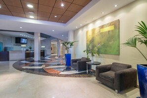 A spacious lobby with a check-in counter, seating area, and a large abstract painting on the wall. - Benalmadena Principe 3p4p Balcon (Benalmádena)