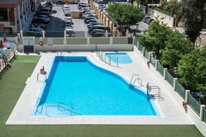 A rectangular swimming pool with a diving board and steps, surrounded by a fence and a green lawn. - Benalmadena Principe 3p4p Balcon (Benalmádena)