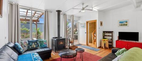 A living room with a fireplace, a sofa, a television, and a red cabinet.