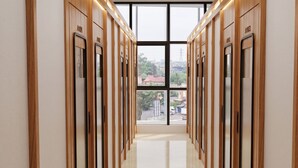A hallway with wooden paneling and numbered doors leading to rooms. - Dreampod Soekarno Hatta Airport (Tangerang)