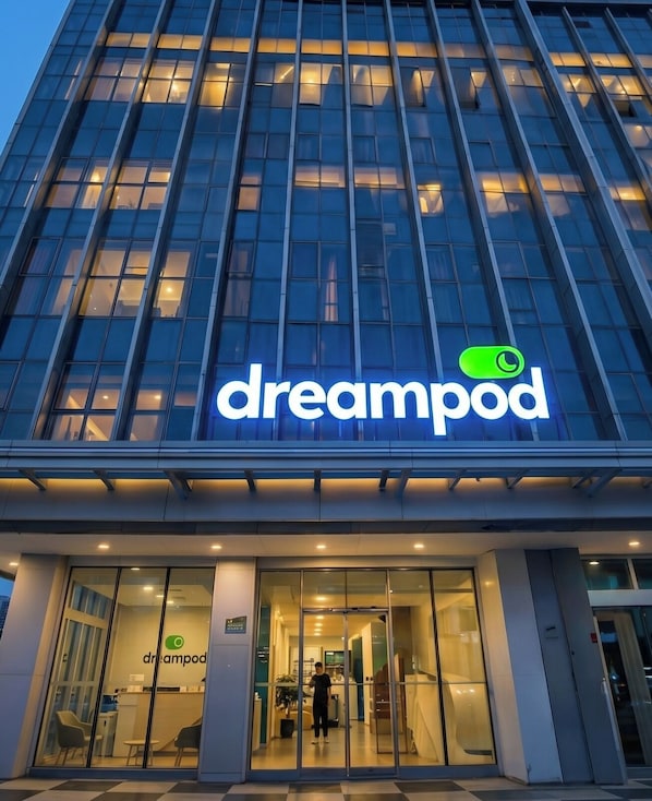 Un edificio moderno con fachada de vidrio y el rótulo 'dreampod'.