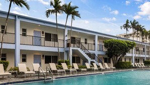 Un hotel con zona de piscina, varios pisos y balcones.