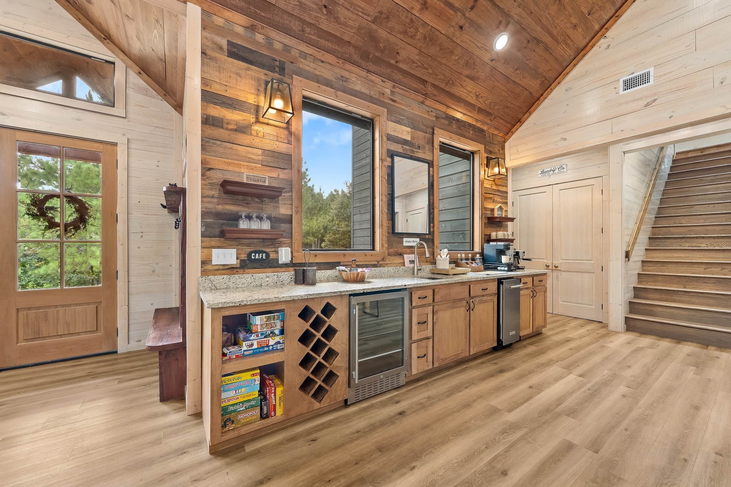 A kitchen with wooden walls, a built-in wine rack, and a view of the outdoors.