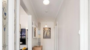 A hallway with wooden flooring, white walls, and a ceiling light. - Spacious Multifunctional 5BR Retreat with Backyard (Bayswater)