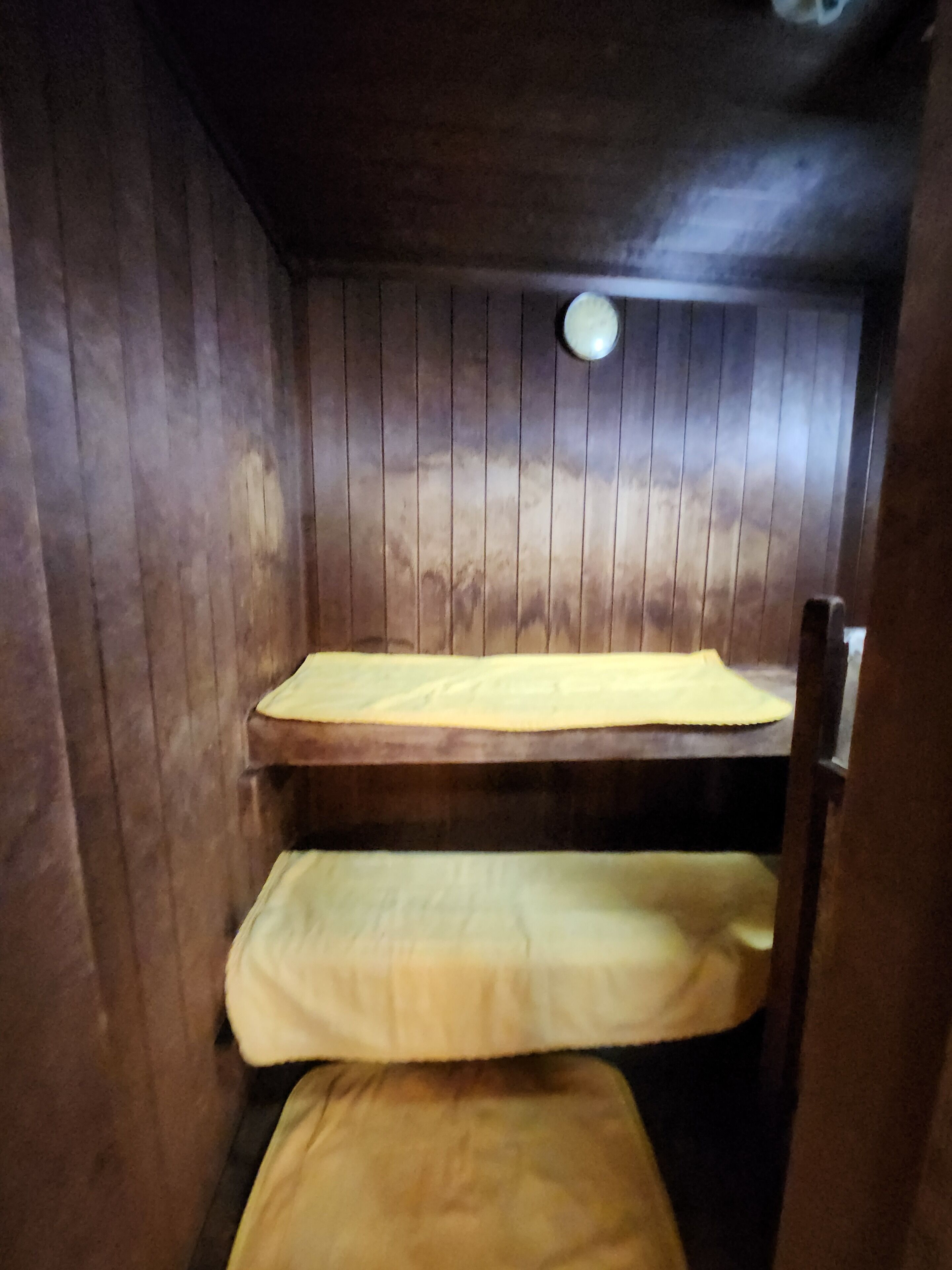 Una cama litera con colchón amarillo y cabecera de madera.