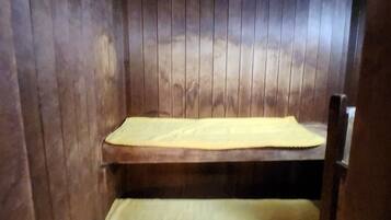 A bunk bed with a yellow mattress and a wooden headboard.