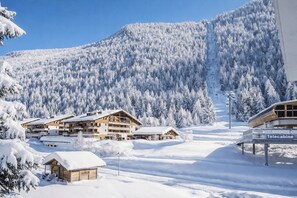 Eine verschneite Berglandschaft mit einer Seilbahn und Gebäuden.