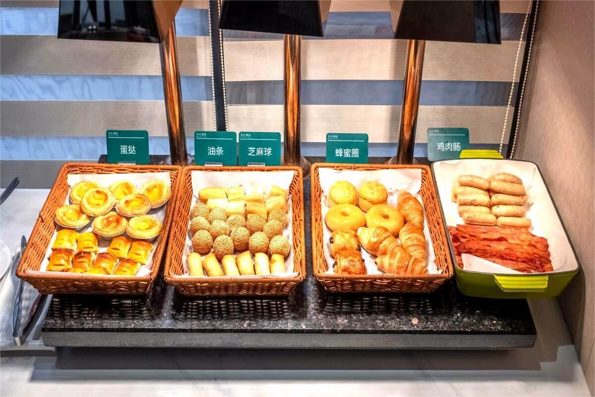 A buffet with labeled baskets of various pastries and meats.
