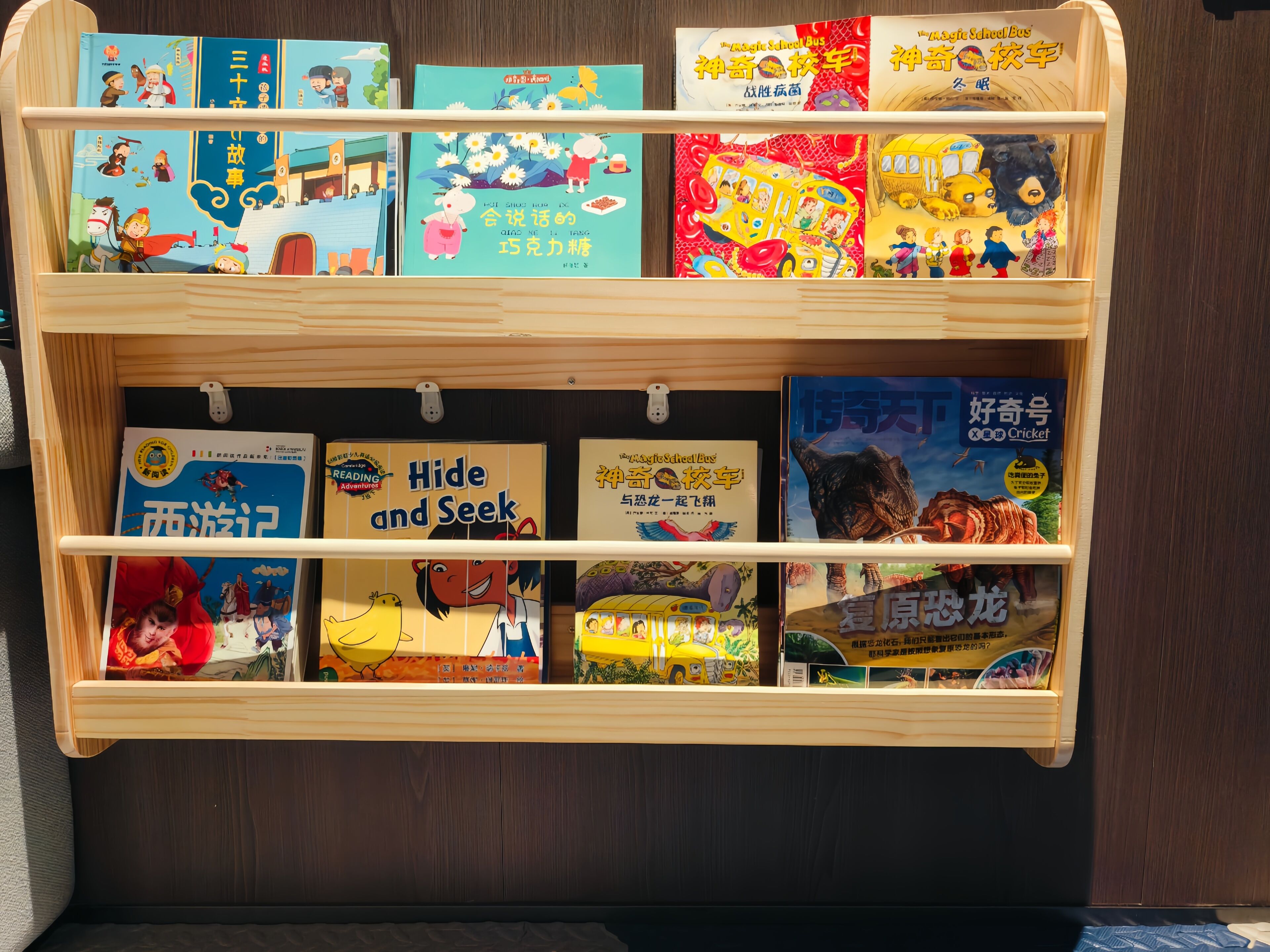 Una estantería de madera con libros infantiles, incluyendo títulos como 'Hide and Seek' y 'Goodnight Moon'.