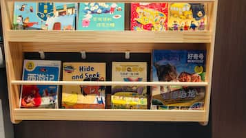 Una estantería de madera con libros infantiles, incluyendo títulos como 'Hide and Seek' y 'Goodnight Moon'.