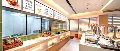 A buffet setup with various food items and clear signage.