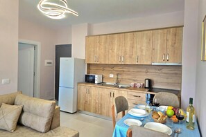 Eine moderne Küche mit Holzschränken, einem Esstisch gedeckt mit Tellern, Gläsern und einer Weinflasche.