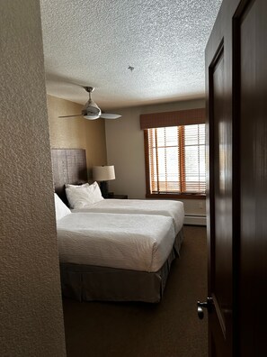 A hotel room with two beds, a ceiling fan, a window with blinds, and a door. - 2-bedroom Hyatt Main Street Station - Peak 9 in Breckenridge with Mountain View (Breckenridge)