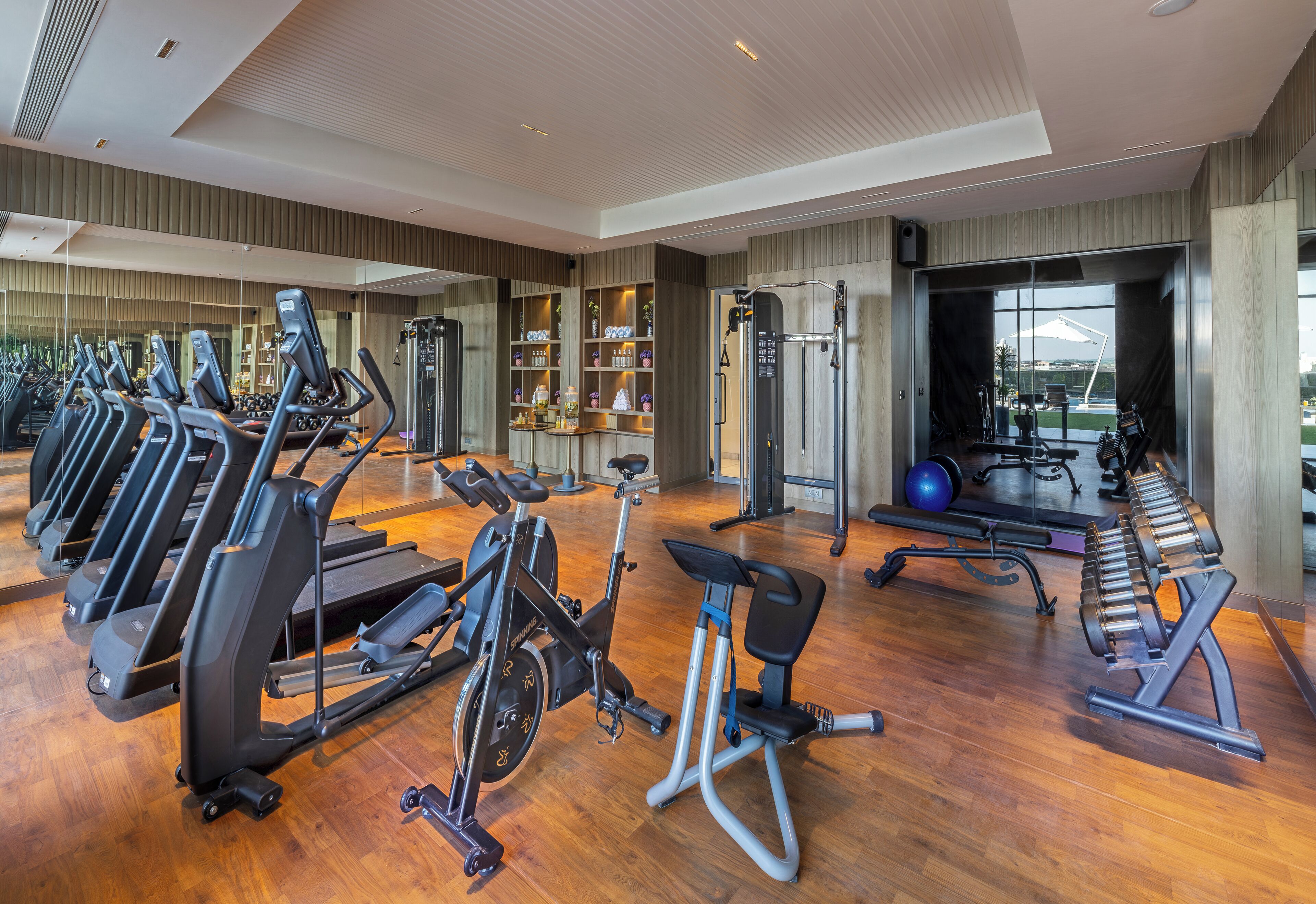 Gimnasio con cintas de correr, elípticas y equipo de pesas.