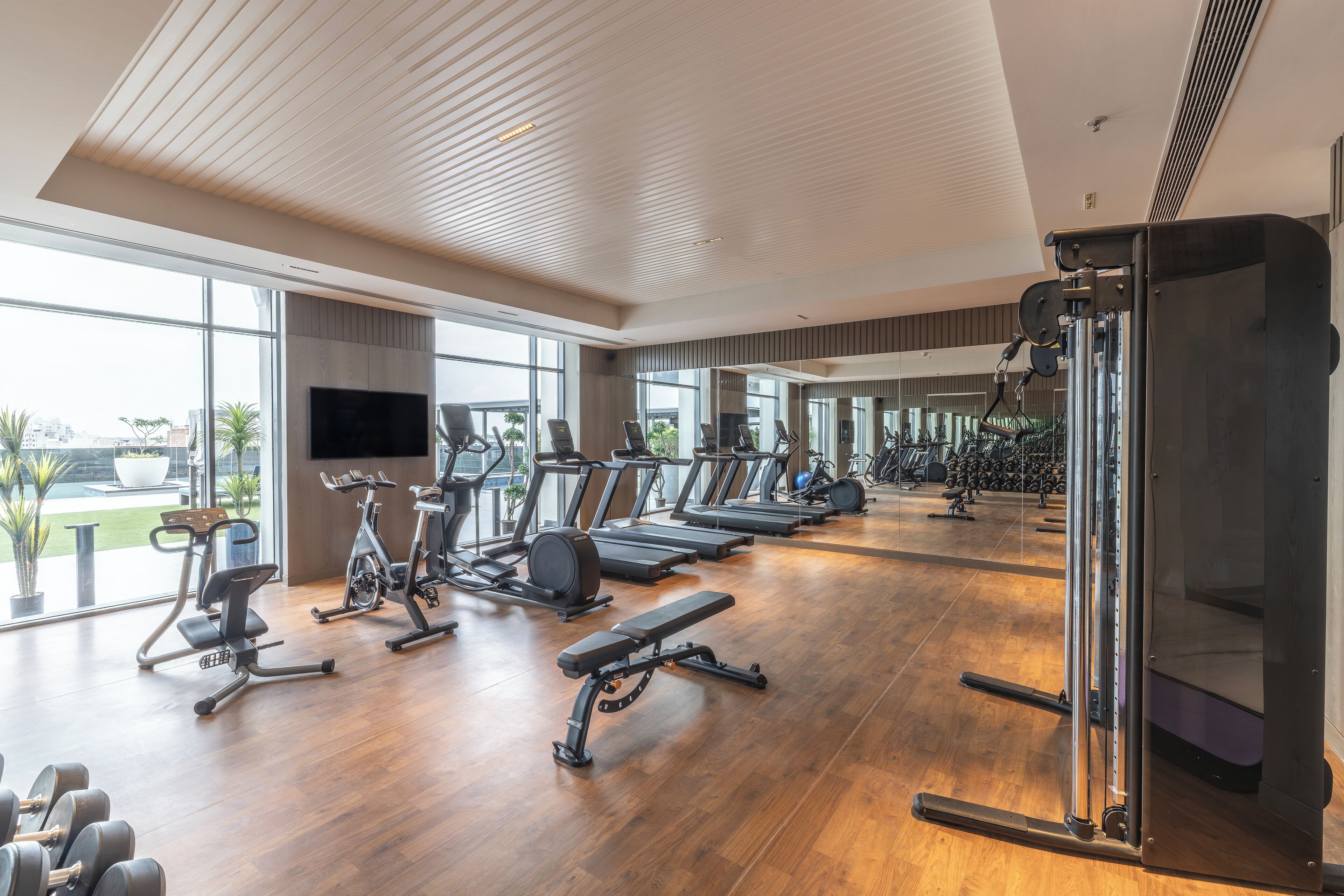 Een fitnessruimte met loopbanden, elliptische trainers en losse gewichten.
