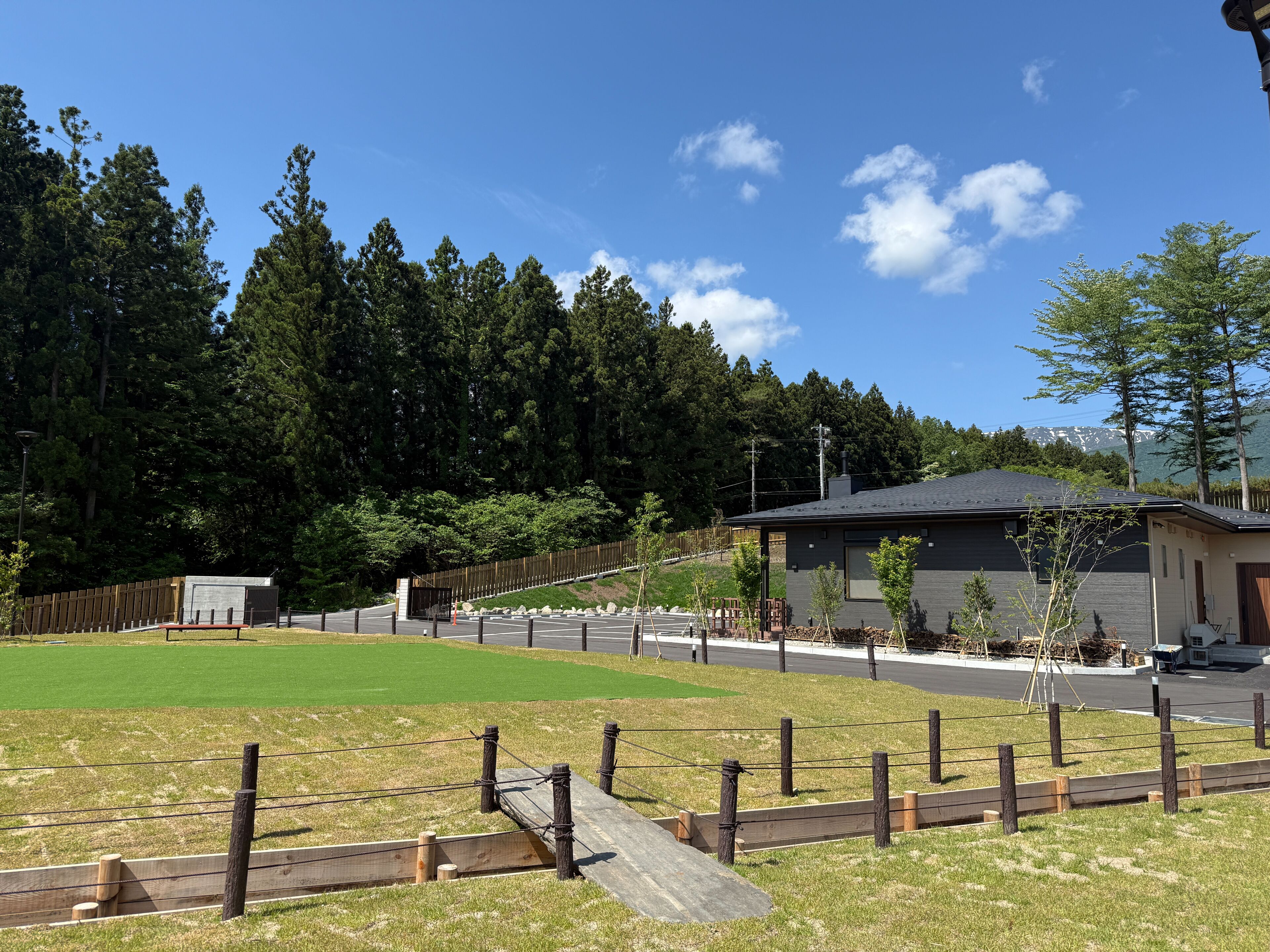 A residential area with a house, a fenced yard, and a road.