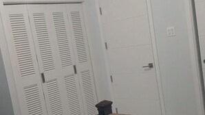 Quarto com cama, guarda-roupa e ar condicionado.