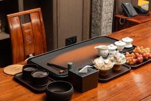 Ein traditioneller japanischer Teezeremoniestuhl mit einer Tatami-Matte, Teeutensilien und einem Holztisch.