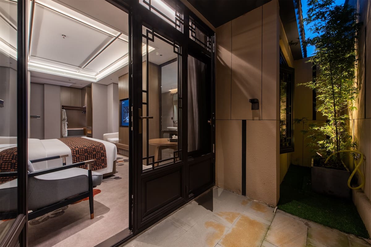 Ein modernes Hotelzimmer mit einem großen Bett, einem Schreibtisch und einem Fernseher.