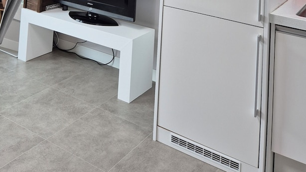 A modern kitchen with a white refrigerator, a built-in oven, and a flat-screen TV on a white stand. - pacific (Gyeongju)