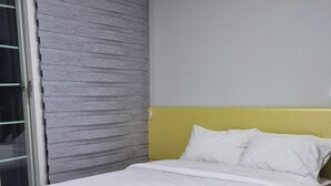 A bedroom with a bed, a window with blinds, and a door. - pacific (Gyeongju)
