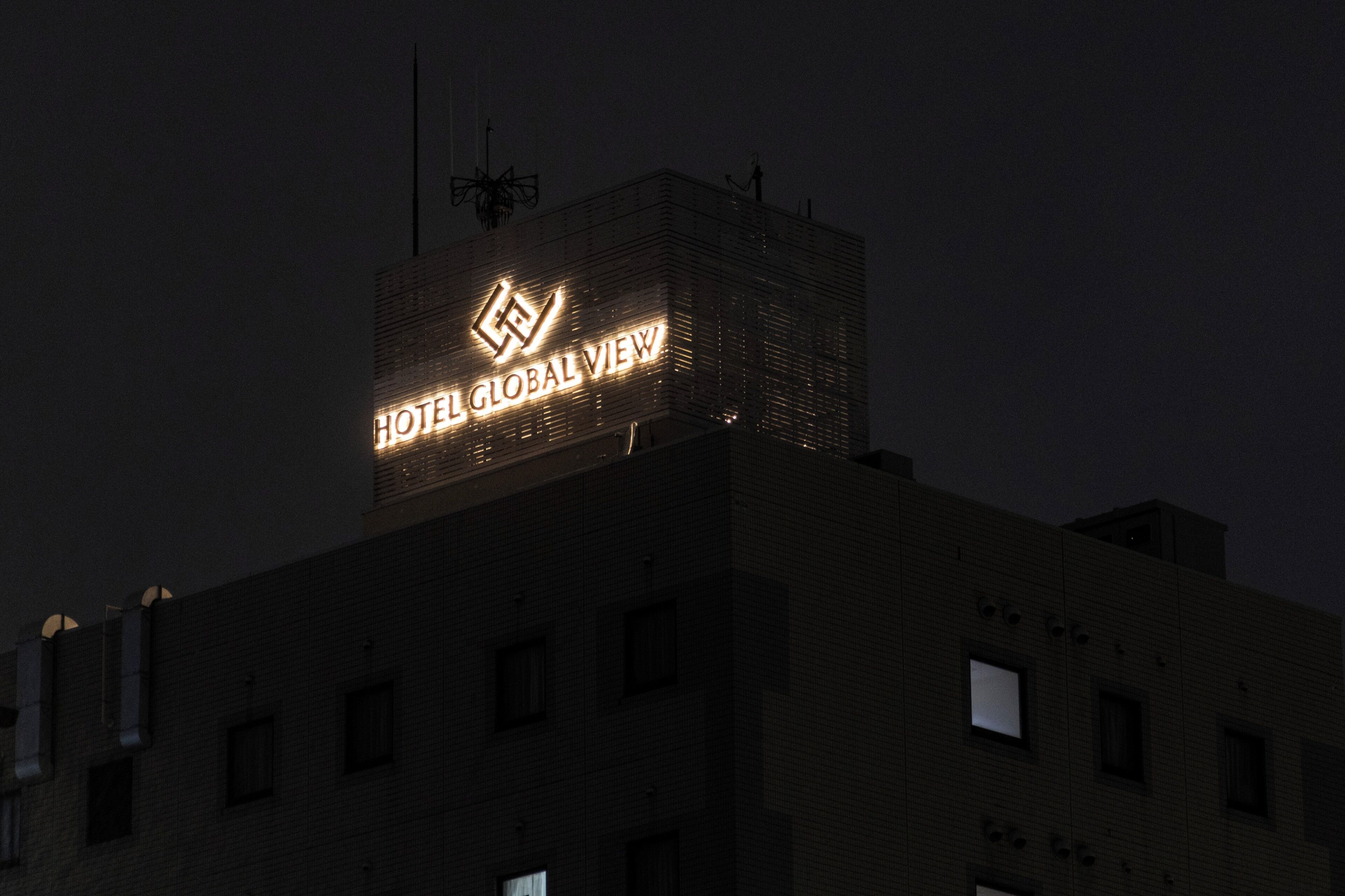 Un edificio con un letrero que dice 'HOTEL GLOBAL VIEW' en la azotea.