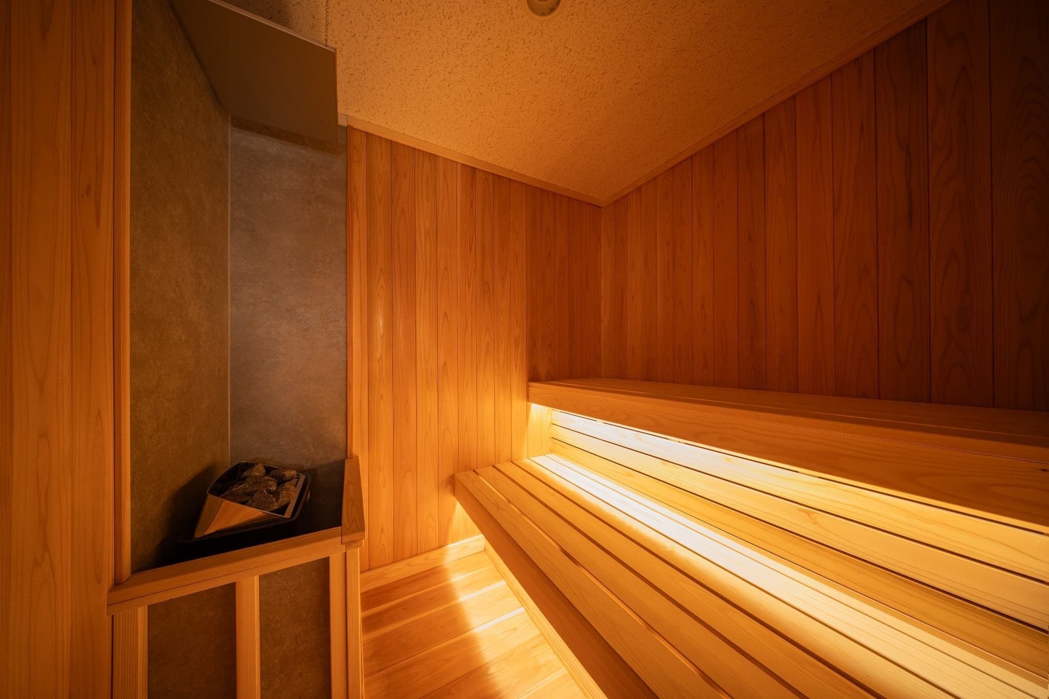 Una sauna con bancos de madera y un banco con una bandeja.