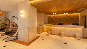 A modern reception area with a wooden ceiling, a reception desk, and two wicker rocking chairs. - Hotel Global View Iwaki (Iwaki)