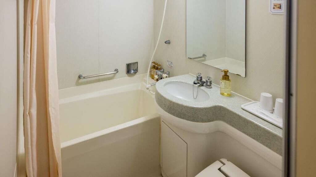 Un baño con bañera, lavamanos y espejo.