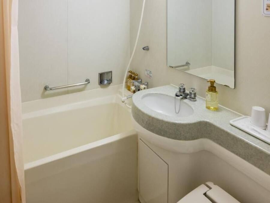 Un baño con bañera, lavamanos y espejo.