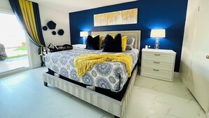 A bedroom with a bed, bedside tables, a lamp, and a painting on the wall. - Modern & Cozy Retreat Game Room, Family-Friendly (North Las Vegas)