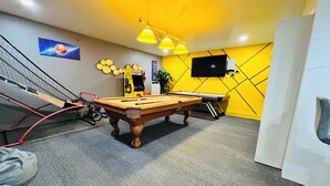 A billiards room with a pool table, a snooker table, and a television on the wall. - Modern & Cozy Retreat Game Room, Family-Friendly (North Las Vegas)