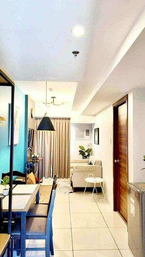 Una sala de estar moderna con comedor, un sofá, una mesita y un mueble aparador.