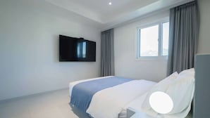 A modern hotel room with a large bed, a flat-screen TV mounted on the wall, and a window with curtains. - THE M HOTEL (Seoul)