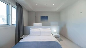 A modern hotel room with a large bed, bedside tables, a nightstand, a window with curtains, and a ceiling light fixture. - THE M HOTEL (Seoul)