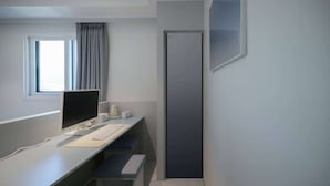 A modern office space with a desk, computer, and a large vertical black panel on the wall. - THE M HOTEL (Seoul)