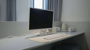 A modern office cubicle with a desktop computer, keyboard, mouse, and a coffee maker. - THE M HOTEL (Seoul)
