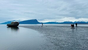 Un barco en aguas tranquilas con montañas al fondo.
