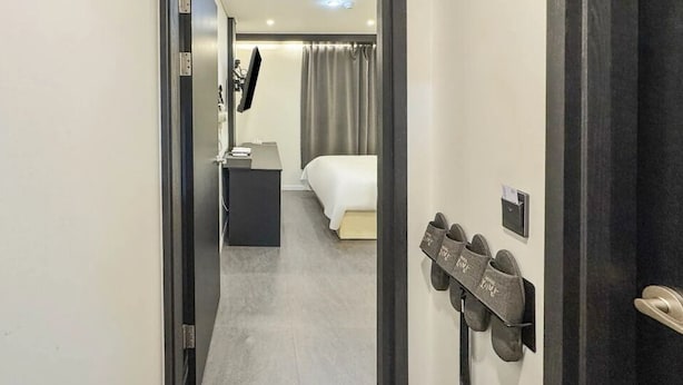 A hotel room with a bed, a desk, a TV, and shoe storage. - Hotel Boribat SeokNam (Incheon)