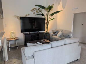 A living room with a sofa, a TV, a lamp, and a plant. - Serene Canyon-Side 2BR/2Bath + Loft Sleeps 6 @ Central SD  near tech hubs  & UTC (San Diego)