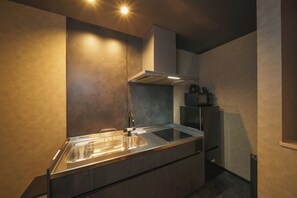 A modern kitchen with a stainless steel sink, a range hood, and a built-in oven. - GAON (Beppu)