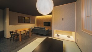 A modern interior with a dining area, sofa, and a display case. - GAON (Beppu)