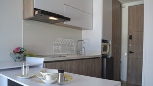 Una cucina moderna con piano di lavoro bianco, elettrodomestici in acciaio inossidabile e mobili in legno.