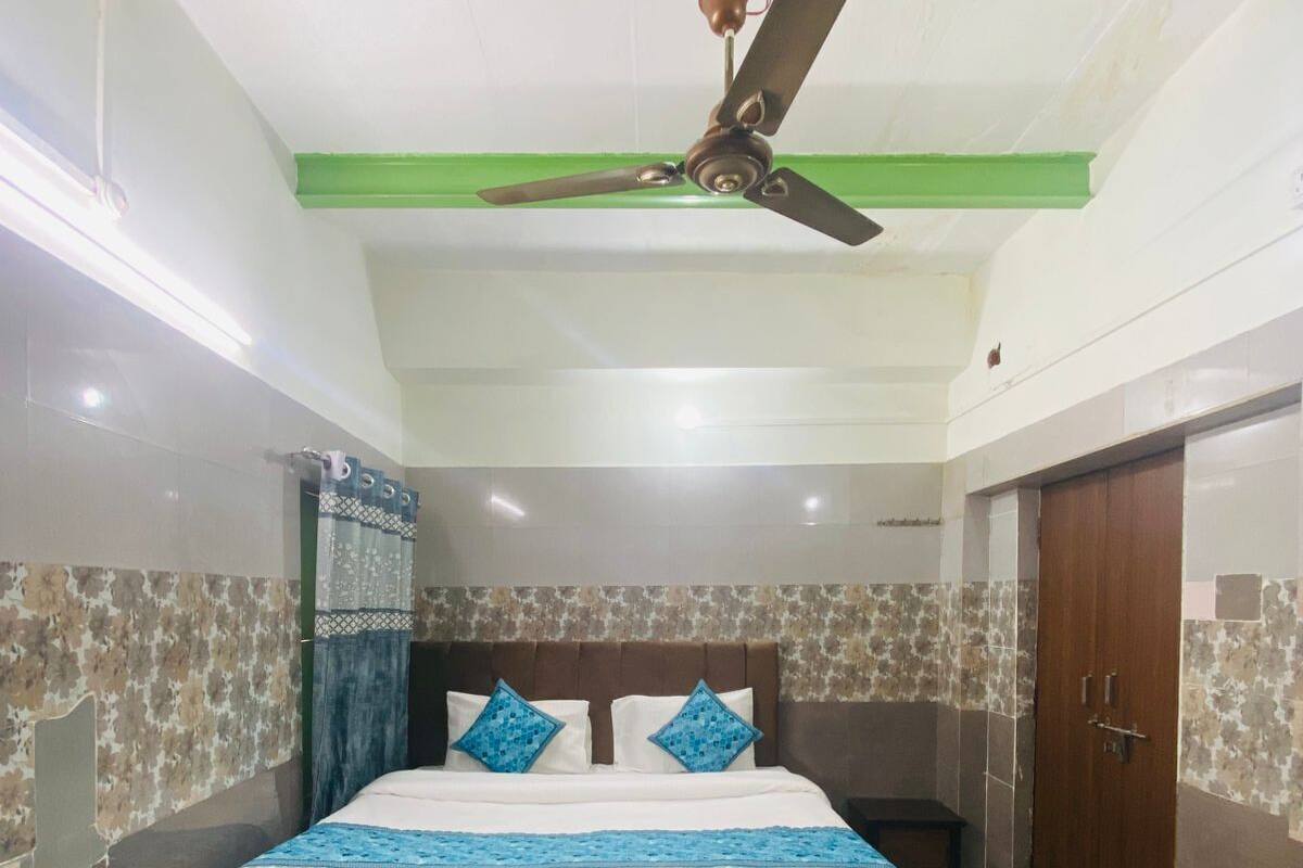 Un dormitorio con cama, ventilador de techo, armario y baño con cortina de ducha.