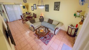 Una sala de estar con un sofá, una mesa de centro y una zona de comedor con sillas y una mesa.
