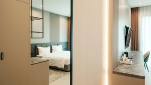A modern hotel room with a bed, a desk, and a TV. - AFTER RAIN HOTEL (Chiang Mai)