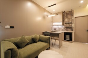 Habitación doble familiar, balcón, vista a la alberca | Área de sala de estar