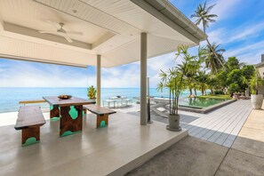 An outdoor patio with a pool, wooden tables, and chairs, overlooking the ocean. - 5 min to Seatran ferry! Private villa with a Panoramic view of the Samui sunset. (Ang Thong Subdistrict, Koh Samui District)